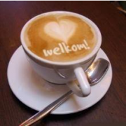 Kopje koffie met "Welkom" in de melk geschreven.